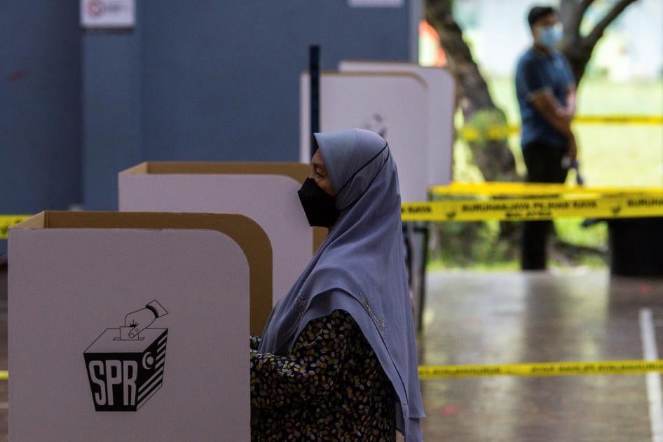 Seorang wanita di sebuah pusat mengundi sedang memasukkan kertas undinya ketika pilihanraya umum ke-15, Kuala Lumpur, Malaysia, 19 November 2022. 