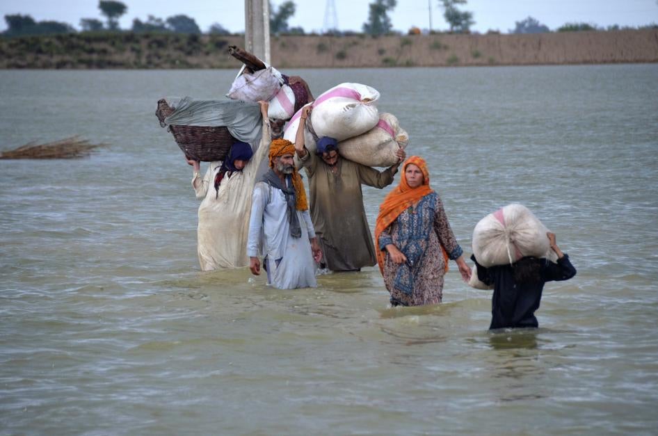 पाकिस्तान के दक्षिण-पश्चिमी बलूचिस्तान प्रांत के जाफ़राबाद में भारी बारिश के बाद बाढ़ प्रभावित इलाके से गुज़रता एक विस्थापित परिवार, 24 अगस्त, 2022.