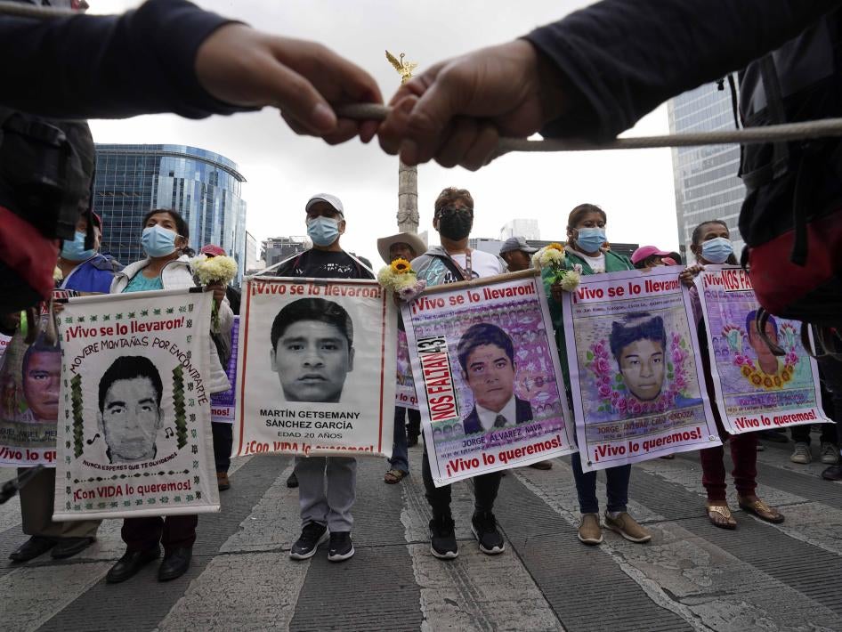 People march with placards showing faces of missing people