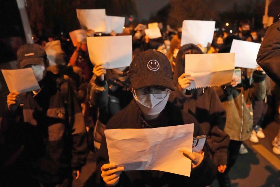 抗议民众手持白纸上街游行并齐呼口号，中国北京，2022年11月27日。