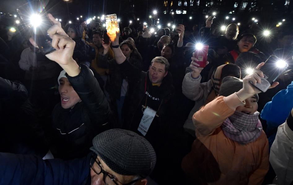 Протестующие поднимают телефоны с включенным фонариком на акции за свободу слова и освобождение политзаключенных в Бишкеке 25 ноября 2022 г. 
