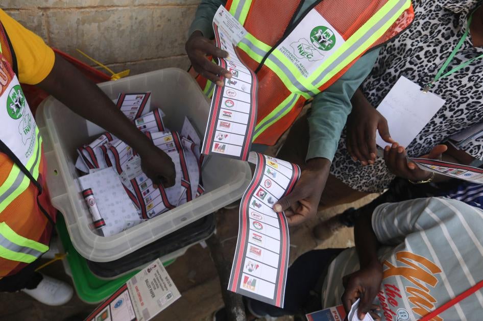Independent National Electoral Commission officials sort and count ballots at a polling station in Kano during Nigeria's election.