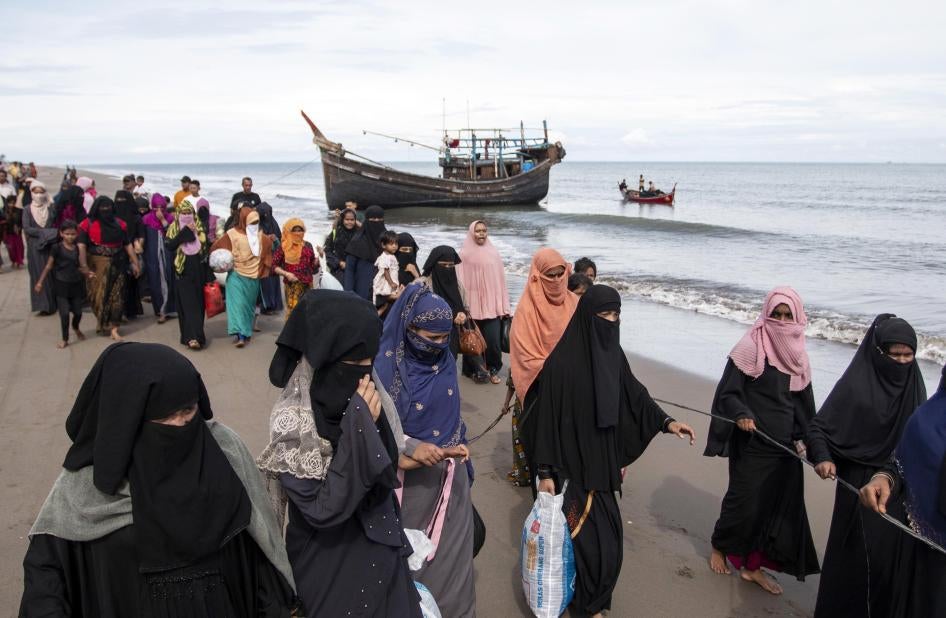 Ethnic Rohingya walk to a temporary shelter after they landed by boat in North Aceh, Indonesia.
