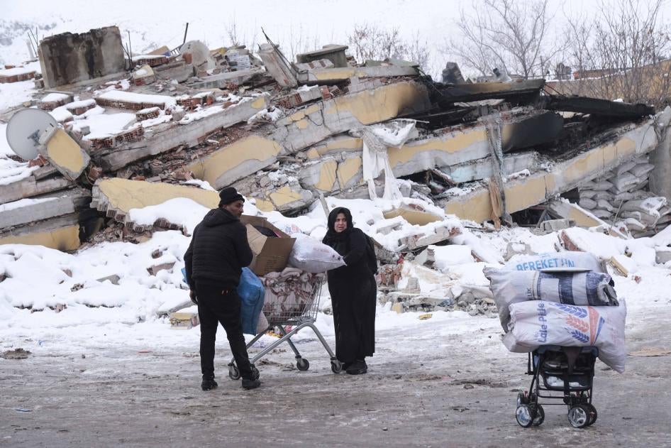 A Syrian refugee couple carry their belongings by shopping cart in Elbistan, Kahramanmaraş province, Turkey, February 8, 2023