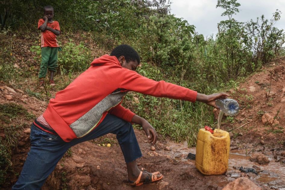 Ein 16-jähriger Junge sammelt Wasser aus einer Quelle in der Nähe der Goldmine Lega Dembi in der Region Oromia in Äthiopien. ©2020 Tom Gardner