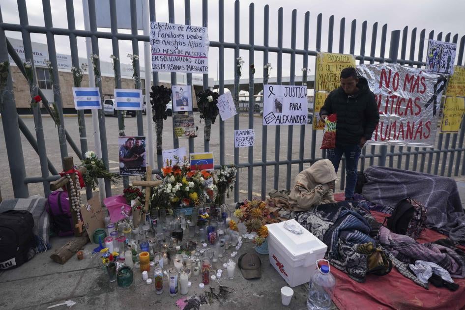 An altar with candles and photos covers the fence outside a Mexican immigration detention center