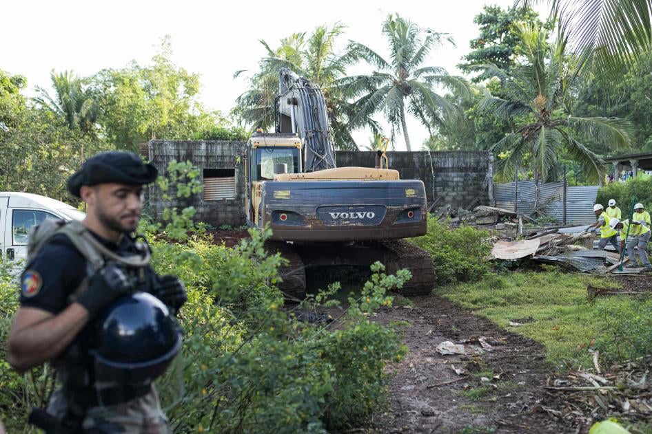 A French gendarme stands guard during the demolition of an informal settlement in Longoni, Mamoudzou, on the island of Mayotte.