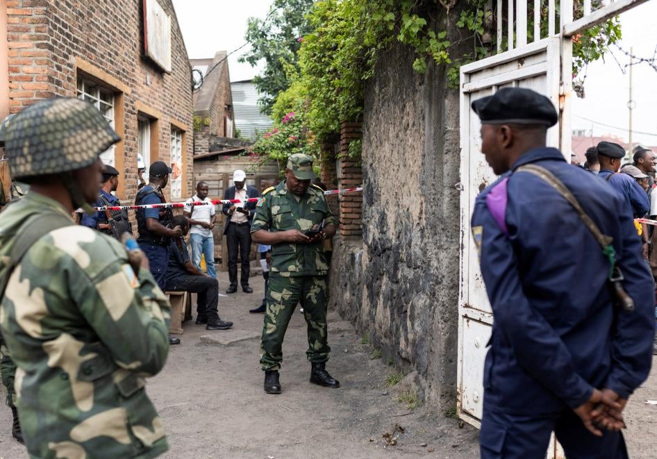 Congolese soldiers stand guard as prospective voters gather to register with the electoral commission in Goma, Democratic Republic of Congo.