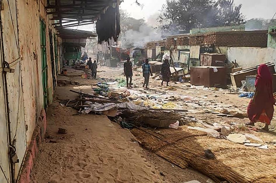 People walk among scattered objects in the market of El Geneina, the capital of West Darfur, after fighting between Sudan's army and the Rapid Support Forces.