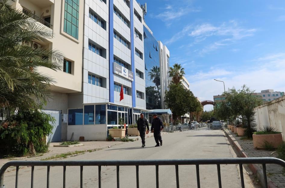 اثنان من أعوان الشرطة يسيران أمام المبنى الكائن فيه مقر حزب النهضة، بعد أن داهمت الشرطة المقر وأخرجت جميع الموجودين فيه، تونس العاصمة، تونس في 18 أبريل/نيسان 2023.