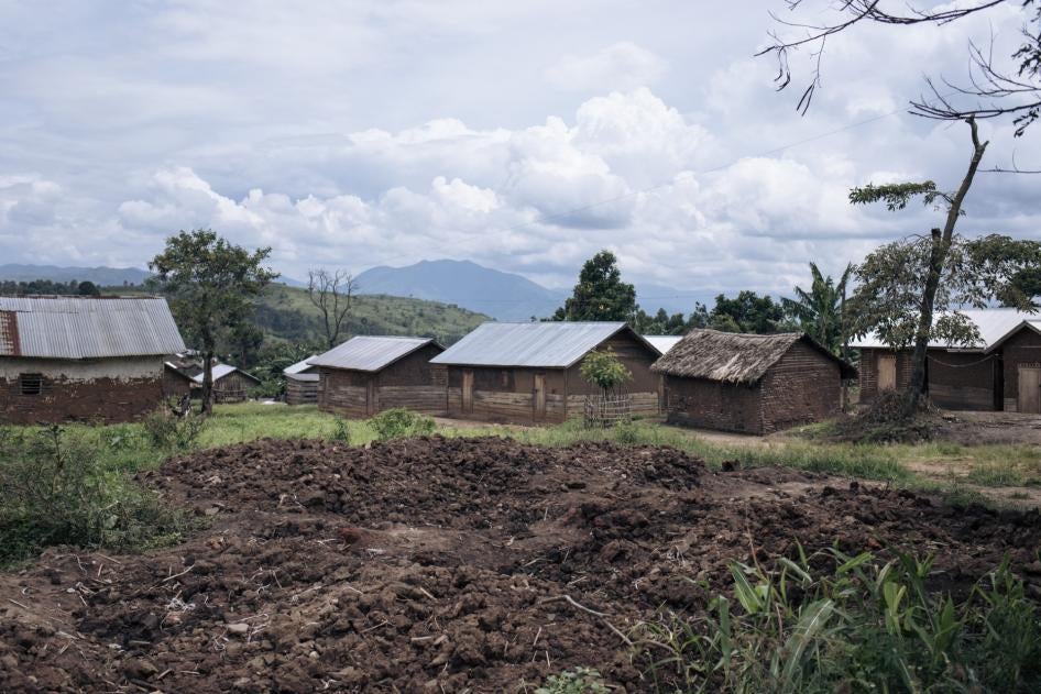 En avant-plan, des amas de terre photographiés le 5 avril 2023 sont visibles sur le site où se trouvait une maison incendiée à Kishishe, au Nord-Kivu, en République démocratique du Congo.