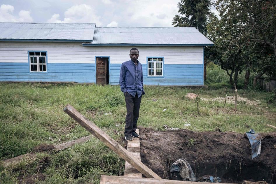 Un homme se tient à l’extérieur d’une école, à côté d’un trou creusé dans le sol par les combattants du M23 pour y détenir des prisonniers, à Kishishe, au Nord-Kivu, en République démocratique du Congo, le 5 avril 2023. 