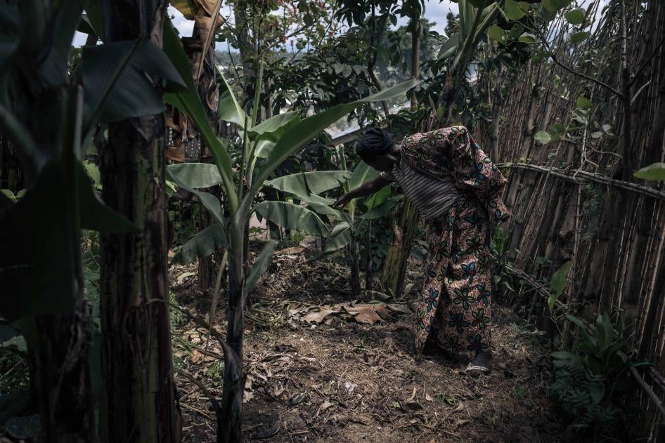 Une femme montre l’emplacement d’une fosse commune entourée de bananiers, où environ cinq hommes et garçons auraient été exécutés par le M23 en novembre 2022 à Kishishe, dans l’est de la République démocratique du Congo. 