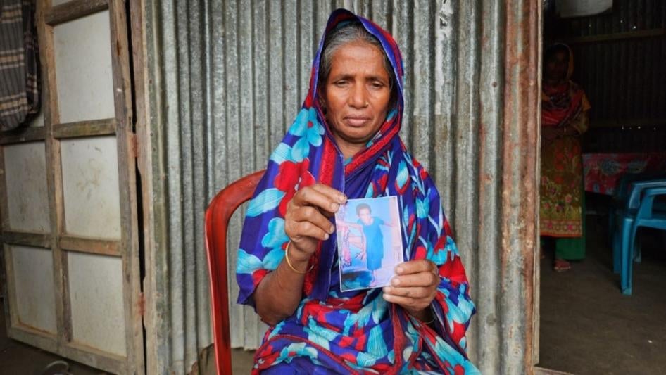 A woman holds up a photo of her child