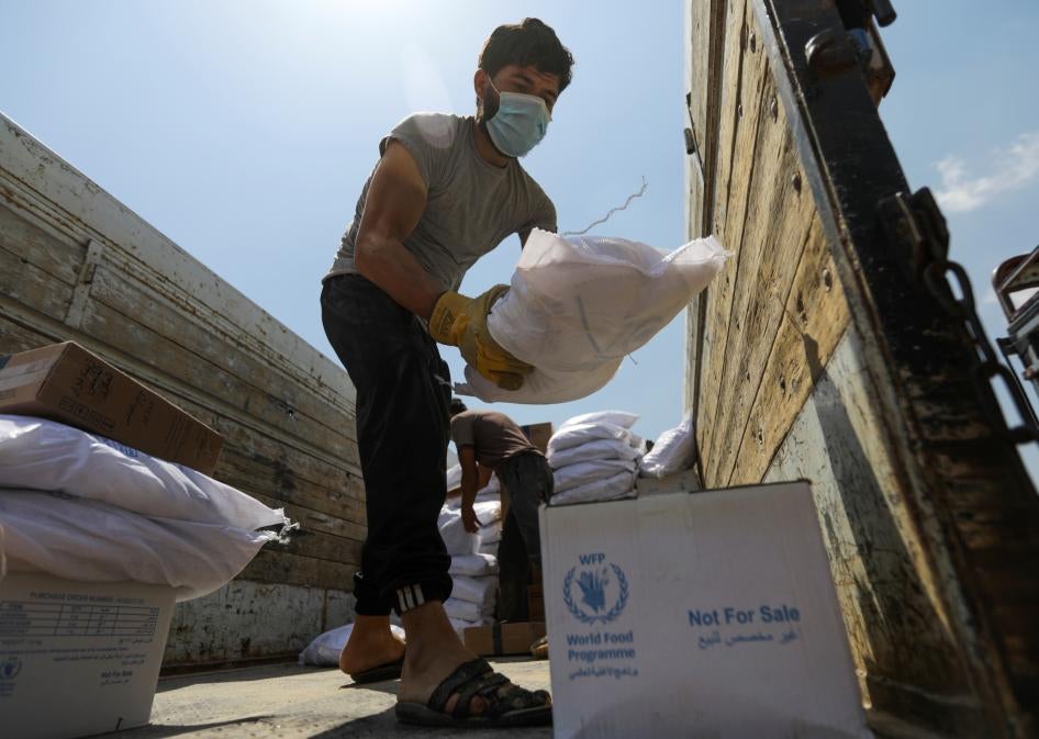 A worker unloads bags and boxes of humanitarian aid from the back of a truck in the opposition-held Idlib, Syria, June 9, 2021.