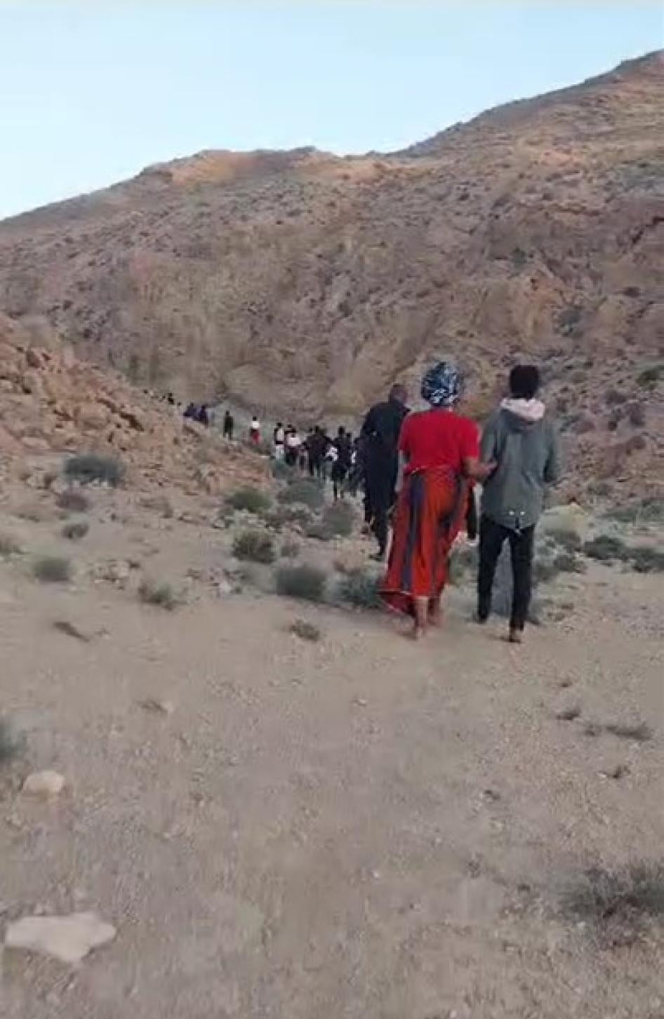 Black African migrants and asylum seekers walk in the desert near the Tunisia-Algeria border between July 5 and 7, 2023 after collective expulsion or forcible transfer there from Sfax, Tunisia, by Tunisian security forces. © 2023 Private