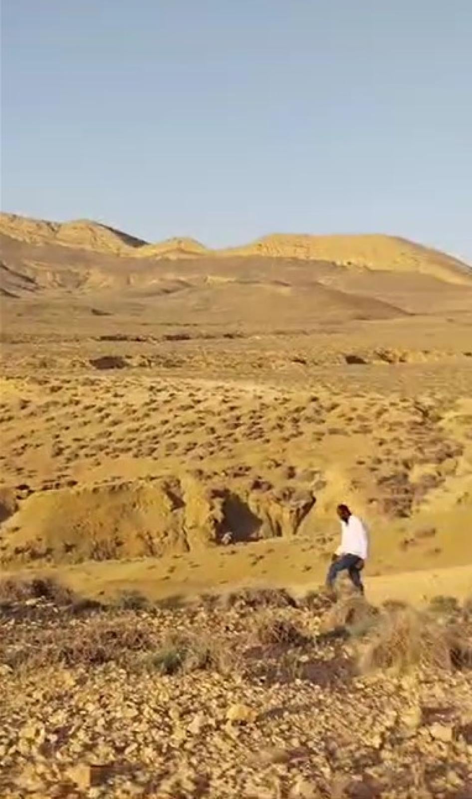 Un homme marche dans le désert près de la frontière tuniso-algérienne entre le 5 et le 7 juillet 2023, après l’expulsion collective ou le transfert forcé de groupes de migrant·e·s et de demandeur·euse·s d’asile africain·e·s noir·e·s depuis Sfax, en Tunisie, par les forces de sécurité tunisiennes. © 2023 Privé
