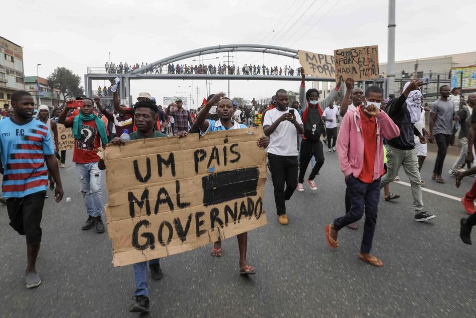 People hold up a sign that reads “A country badly governed” during a march against rising fuel prices and the end of street vending in Luanda, Angola, June 17, 2023. © 2023 ROGERIO/EPA-EFE/Shutterstock