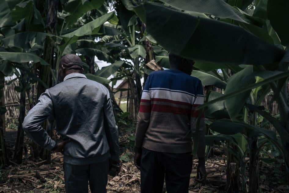 Des hommes se tiennent près d'une fosse commune où cinq hommes et garçons auraient été exécutés par le groupe armé M23 en novembre 2022 à Kishishe, dans l'est de la République démocratique du Congo, le 5 avril 2023.