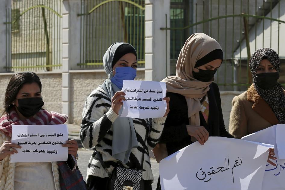 نساء أمام "المجلس الأعلى للقضاء" يحملن لافتات أثناء احتجاج على قرار للمجلس، وهو هيئة تديرها سلطات "حماس". يسمح القرار لأولياء الأمر، وهم غالبا الآباء أو أحد الأقارب الذكور، بمنع النساء غير المتزوجات من السفر خارج قطاع غزة. مثل هذه القيود تحبس النساء في غزة بشكل أكبر بعد القيود الإسرائيلية والمصرية على التنقل، التي حولت قطاع غزة إلى "سجن في الهواء الطلق". مدينة غزة، فلسطين، 16 فبراير/شباط 2021.