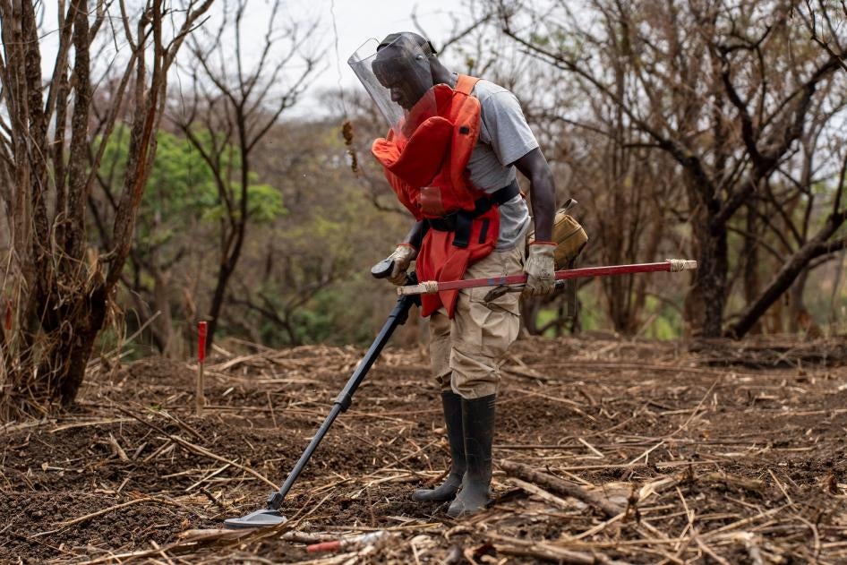Un membre d’une équipe de déminage de l’organisation DCA utilisait un détecteur de mines dans une zone boisée suspectée d'être contaminée par des restes d’engins explosifs de guerre à Pajok, au Soudan du Sud, en février 2023.