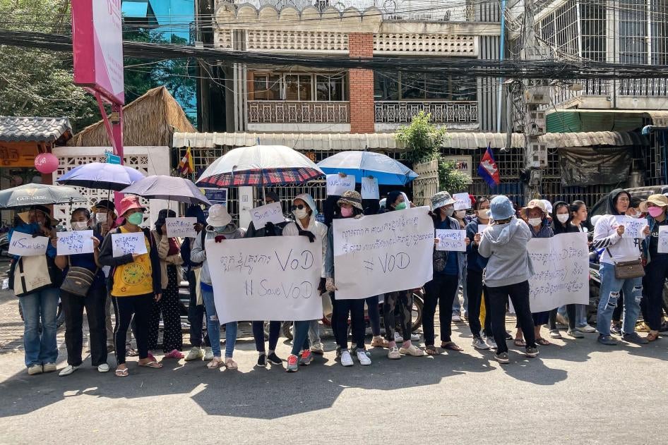 Supporters of online media outlet Voice of Democracy (VOD) hold placards in front of VOD office in Phnom Penh on February 13, 2023.