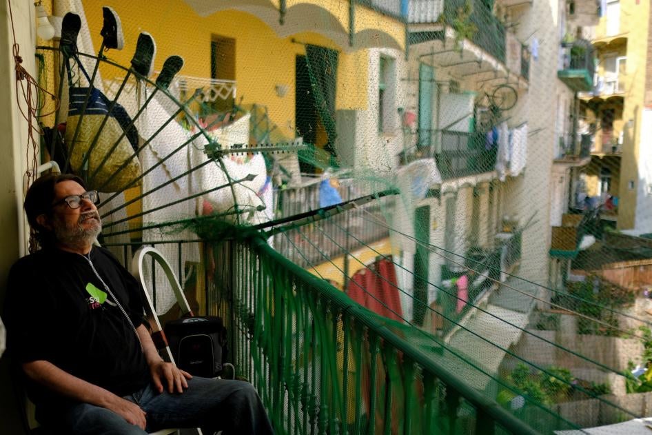Fernando Uceta, que padece EPOC, utiliza un concentrador de oxígeno portátil para respirar mientras está sentado en el balcón de su casa durante la ola de calor del verano, en el barrio del Raval de Barcelona, España, 27 de junio de 2023. 