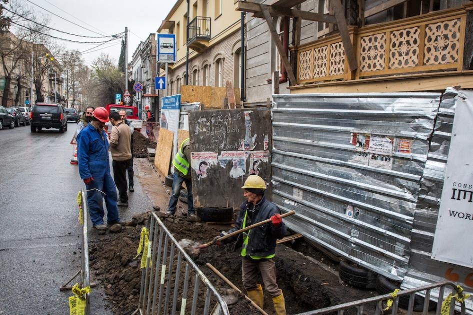 Workers dig up the side of a road in Tbilisi, Georgia, March 23, 2018. 