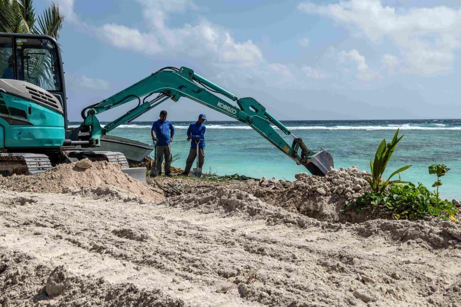Deux ouvriers surveillaient l’avancée des travaux sur un chantier de construction au bord la mer aux Maldives, le 9 décembre 2019. 