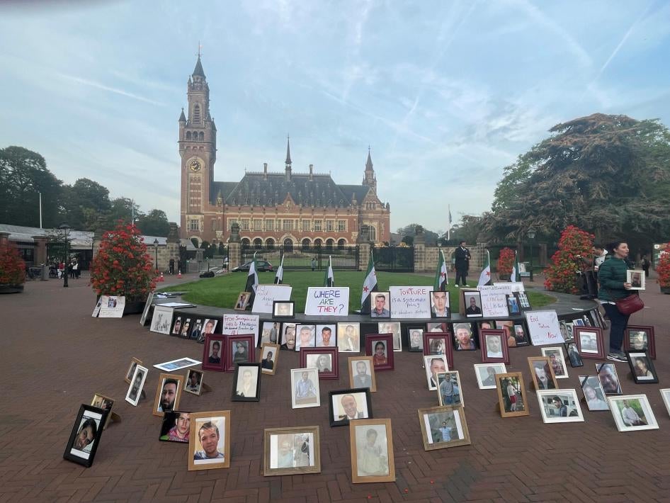 صور لسوريين احتُجزوا أو اختفوا وضعها أقاربهم كجزء من احتجاج أمام محكمة العدل الدولية في لاهاي، هولندا، في 10 أكتوبر/تشرين الأول 2023.