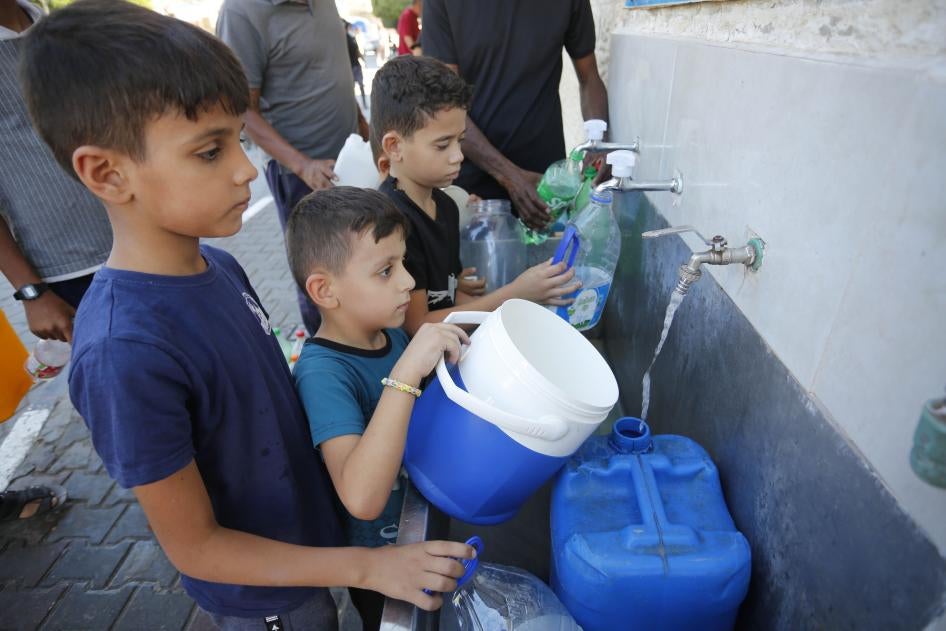 Des enfants remplissaient des bidons à un distributeur d'eau potable à Deir-Al Balah à Gaza, suite à l'arrêt de l'approvisionnement en eau de Gaza par Israël, le 15 octobre 2023. 
