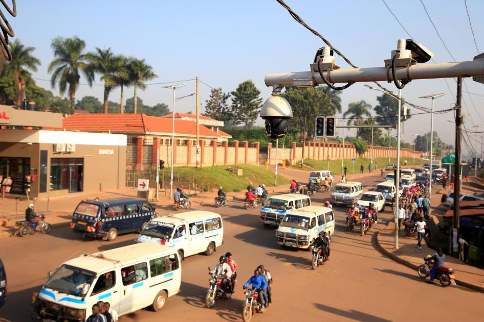 Des véhicules circulent sous le système de caméras de télévision en circuit fermé de surveillance le long de la rue Bakuli à Kampala, en Ouganda, le 14 août 2019.