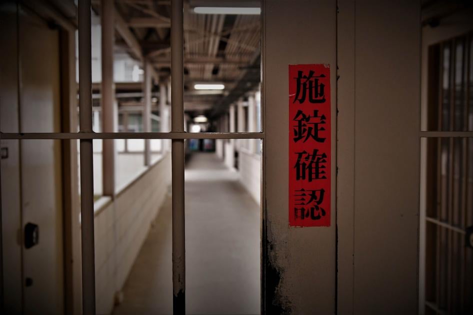 A sign in Japanese reads "check door lock" on a gate inside Tochigi prison