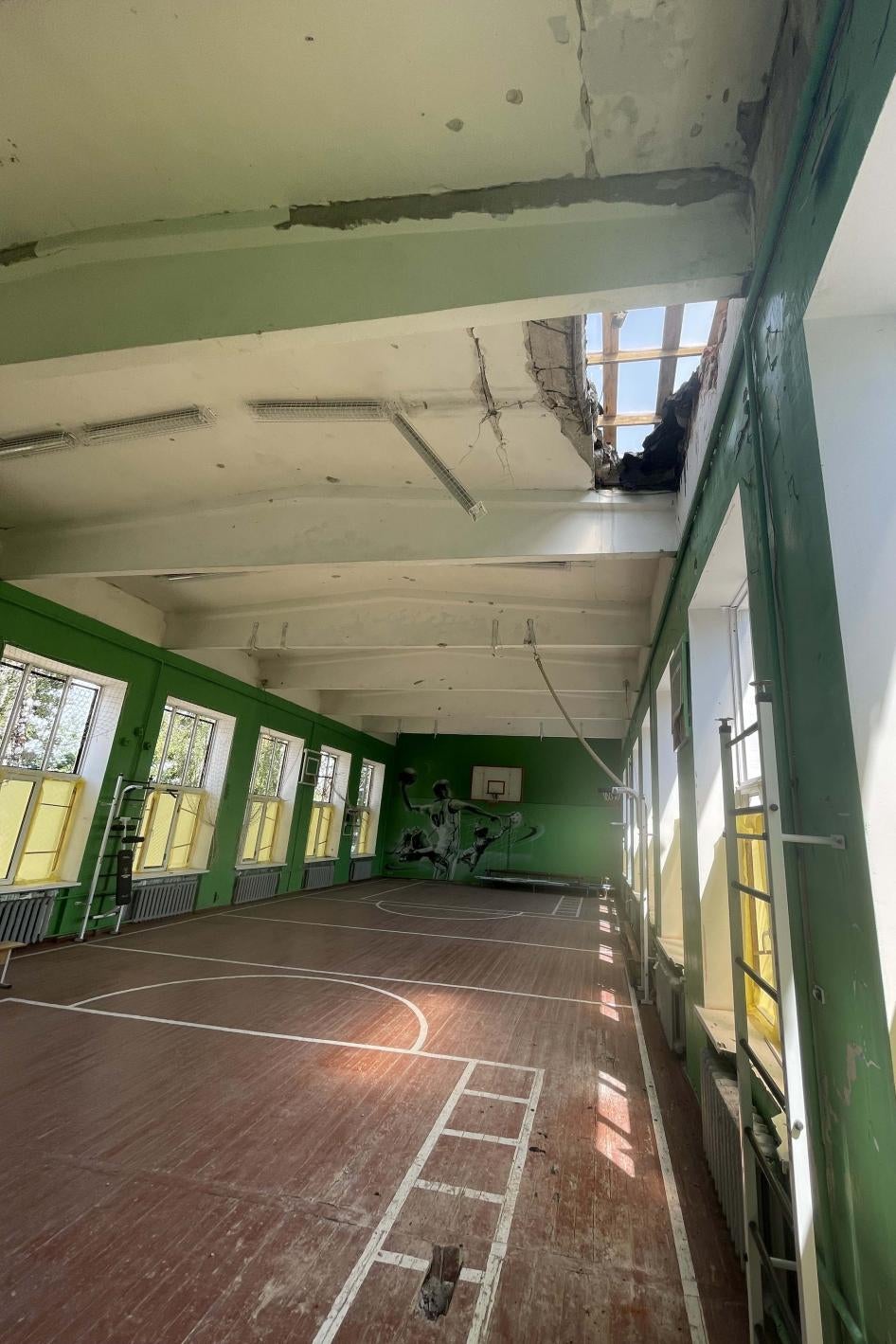 A damaged gymnasium with a hole in the roof