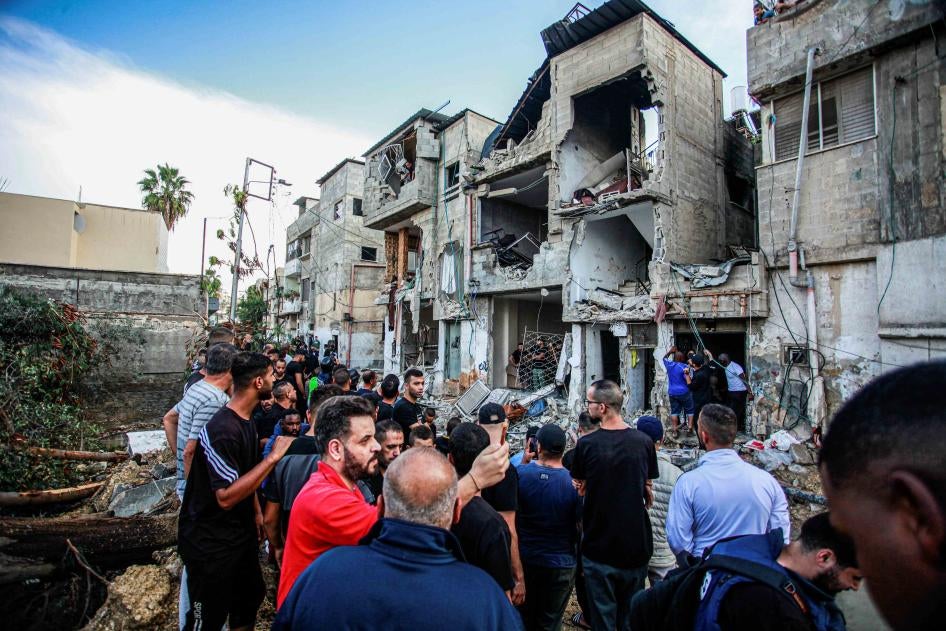 فلسطينيون يتفقدون مبنى متضررا
