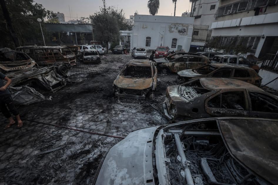 Carcasses de voitures calcinées sur le parking de l'hôpital Al-Ahli à Gaza, photographiées le 18 octobre 2023, au lendemain de l’explosion ayant frappé cette zone le 17 octobre 2023. Ces dégâts pourraient avoir été causés par le propergol d’une roquette provenant d’un tir raté, et qui aurait pu mettre le feu au carburant de ces véhicules garés devant l’hôpital.