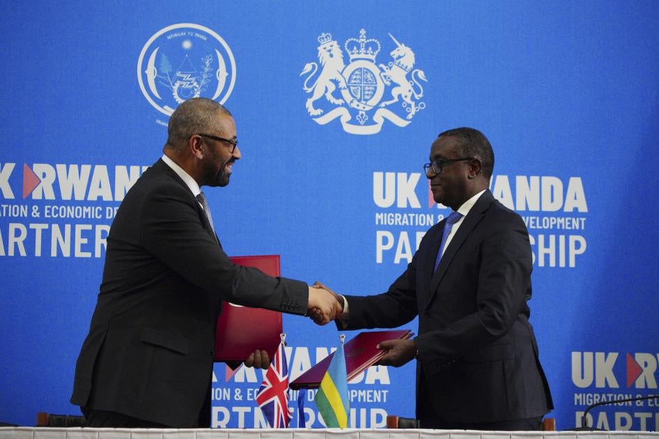 Britain's Home Secretary James Cleverly, left, and Rwandan Minister of Foreign Affairs Vincent Biruta shake hands after signing a new treaty in Kigali, Rwanda, December 5, 2023.