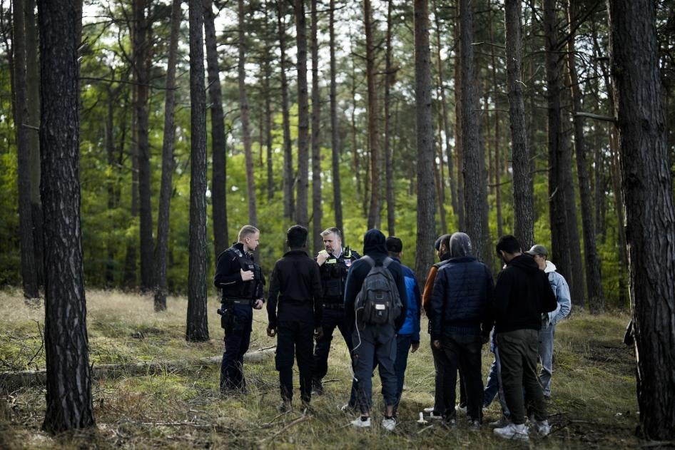 Federal Police officers, on patrol in a forest near Forst south east of Berlin, Germany stand with a group of people who have irregularly crossed the border from Poland into Germany  October 11, 2023