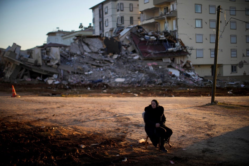 A woman waits beside a building that collapsed in the February 6 earthquakes that devastated provinces of southern Türkiye and killed over 50,000 people, injuring and displacing hundreds of thousands more.  Pazarcık, Kahramanmaraş province, February 13, 2023. 