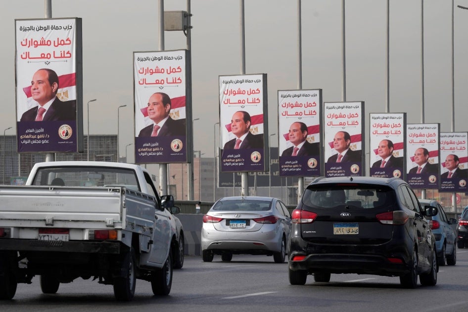 Vehicles pass near banners displaying Egyptian President Abdel Fattah al-Sisi for the presidential elections, in Cairo, Egypt, on December 10, 2023.
