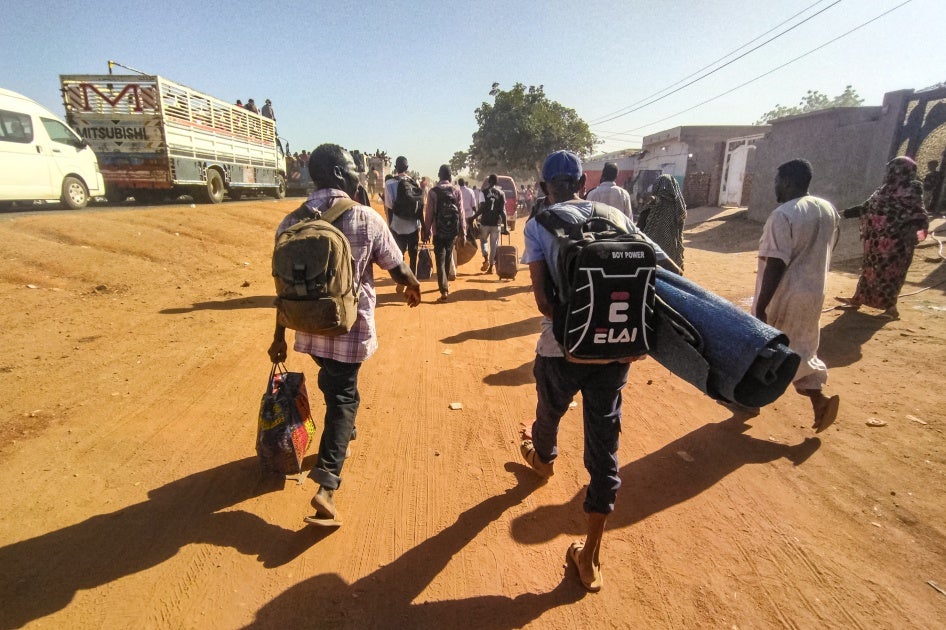 أشخاص هجّرهم النزاع يمشون حاملين مقتنياتهم في ود مدني، عاصمة ولاية الجزيرة، السودان، 16 ديسمبر/كانون الأول 2023. 