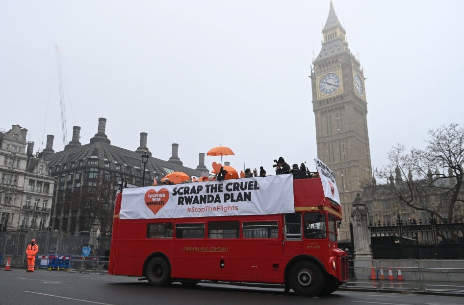 Protesters hold a banner on a red double decker bus 