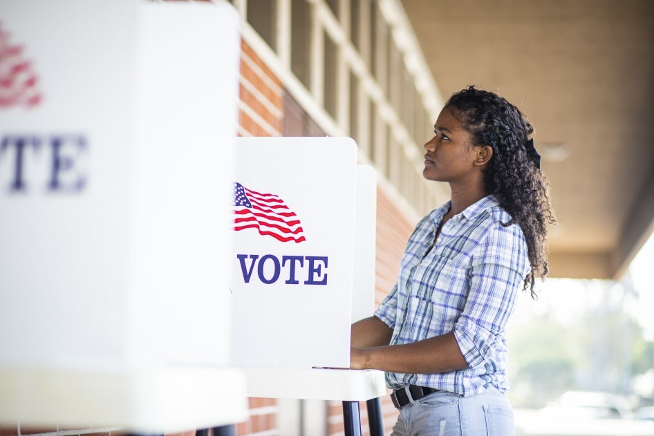 A young black woman voting on election day. 