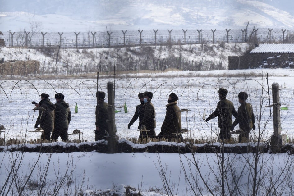 Des soldats nord-coréens patrouillaient dans une zone clôturée au bord d’une rivière dans le comté d’Uiju (province de Pyongan du Nord), près de la frontière avec la Chine, le 22 décembre 2022. 
