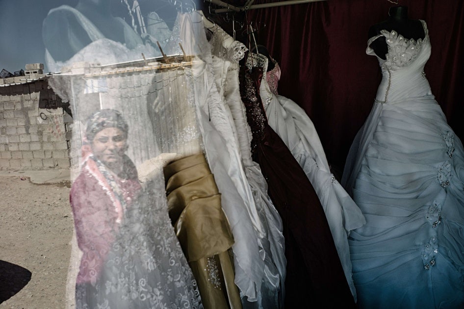 A woman looks at wedding dresses in a store window