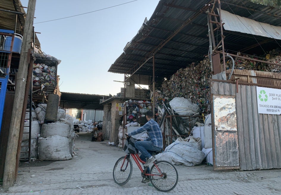 A boy sits on a bicycle in front of a plastic recycling facility in Adana, Turkey.