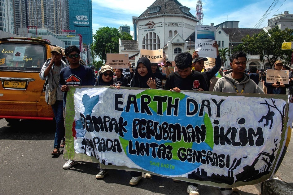 Protesters march with a banner for Earth Day