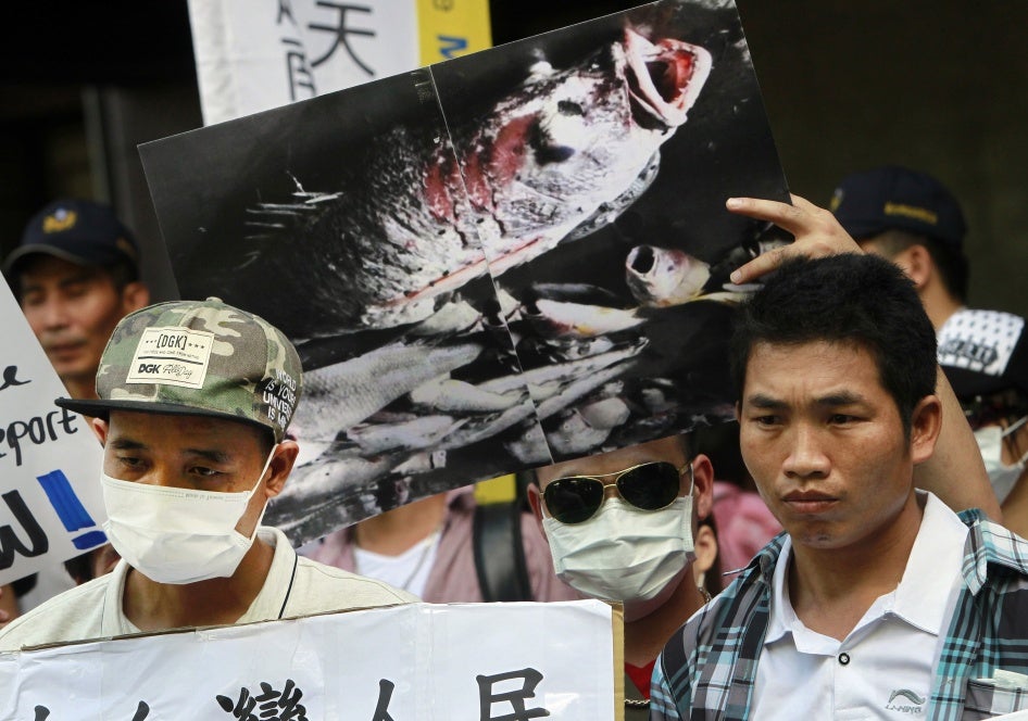 Các nhà hoạt động người Việt cầm bức hình cá chết, nguyên nhân bị cho là do hóa chất độc hại, trong một cuộc tuần hành yêu cầu Tập đoàn Nhựa Formosa nhận trách nhiệm làm sạch môi trường ở Việt Nam, ngày 10 tháng Tám năm 2016, tại Đài Bắc, Đài Loan.