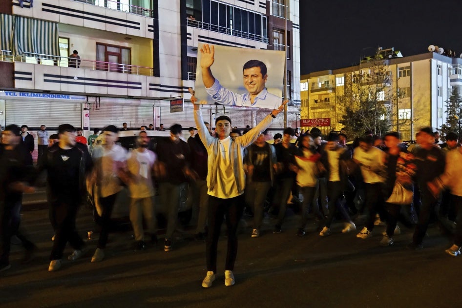 A young man holds up a photo of Kurdish politician Selahattin Demirtaş, in prison since November 4, 2016, at a demonstration in Diyarbakir, Türkiye, April 4, 2024. 