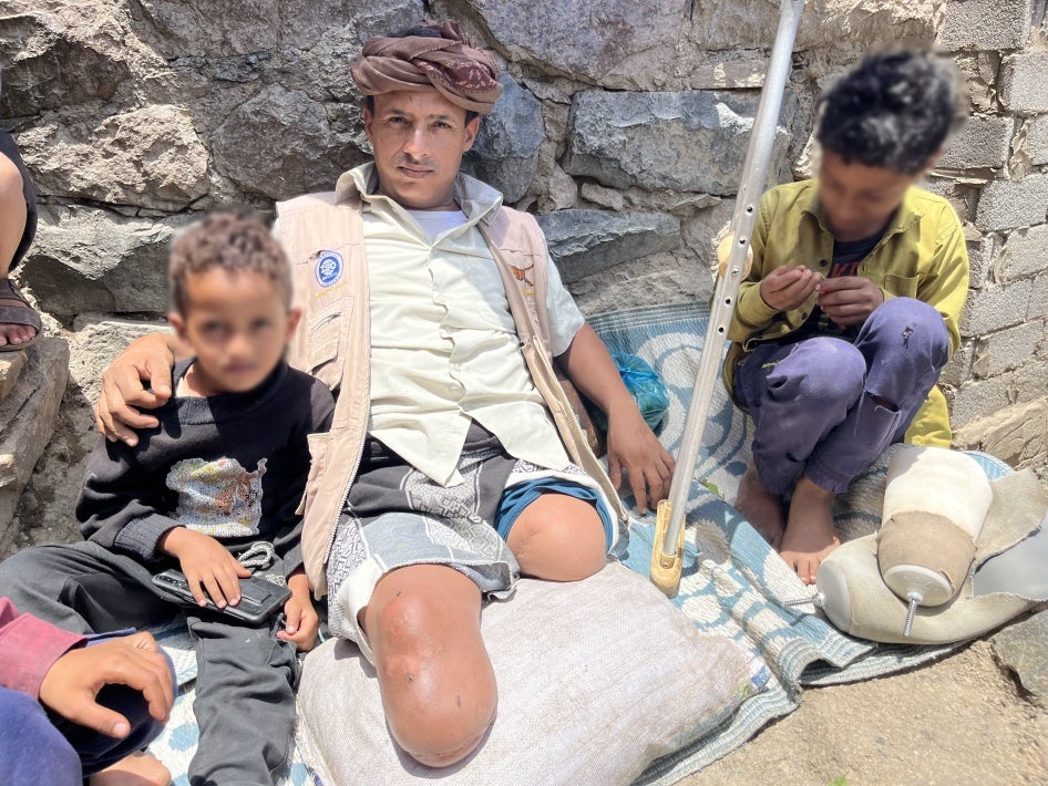Abdullah, 35, who lost both of his legs to a landmine while taking goats to graze, with his two children, Al-Shaqb, Yemen, April 27, 2024. 